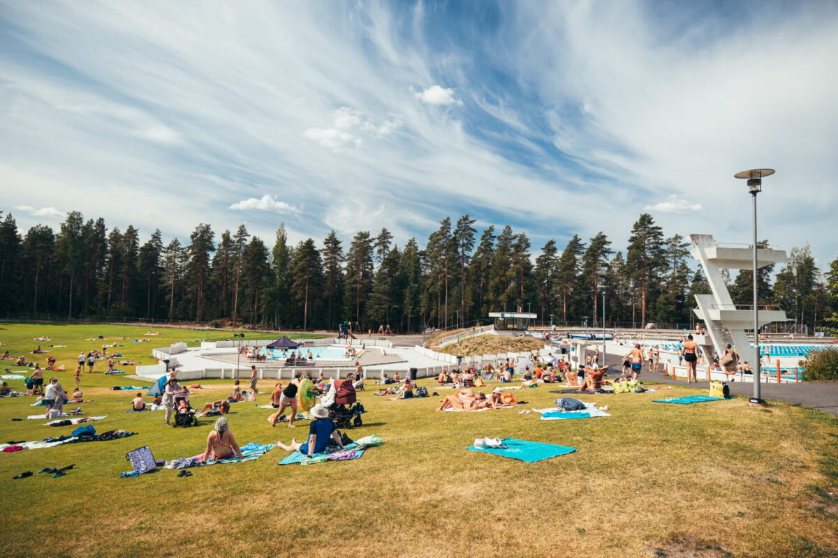Kuvassa ihmisiä nauttimassa aurinkoisesta kesäpäivästä Sveitsin uimalassa.